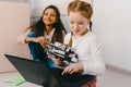 teen schoolgirls programming robot while sitting Royalty Free Stock Photo