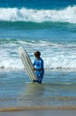 Teen in sea with surfboard