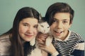 Teen siblings boy and girl cuddle with cat Royalty Free Stock Photo