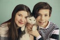 Teen siblings boy and girl cuddle with cat Royalty Free Stock Photo