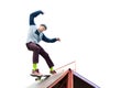 Teen skater in a hoodie sweatshirt and jeans slides over a ramp on a skateboard on white