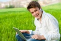 Teen student with laptop outdoors.