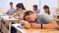 Teen student sleeping at desk in classroom during lesson Royalty Free Stock Photo