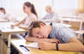 Teen student sleeping at desk in classroom during lesson Royalty Free Stock Photo