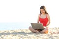 Teen student using a laptop on the beach Royalty Free Stock Photo