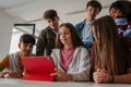Teen students learning together with digital tablet in modern classroom. Royalty Free Stock Photo