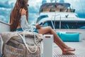 teen texting beside beach bag, yacht rooftop Royalty Free Stock Photo