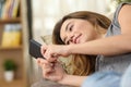 Teen texting in a smart phone lying on couch