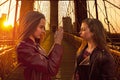 Teen tourist girls taking photo in Brooklyn bridge NY