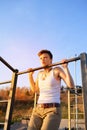 Teen training on horizontal bar outdoors