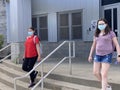 Teen girls wearing surgical masks while leaving school. Royalty Free Stock Photo