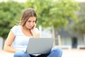 Teen using laptop sitting in the street Royalty Free Stock Photo