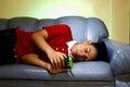 Teen using a smartphone while lying down on a couch and smiling Royalty Free Stock Photo