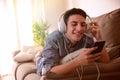 Teen watching multimedia with headphones lying face down on couch