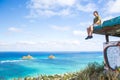 Young man sitting on pillbox over looking Lanikai looking out over the Pacific Ocean loving sitting on top of the world