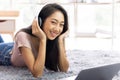 Teen wearing headphones listening to music relax in living room
