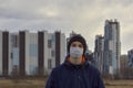 Teen wearing a medical mask against the background of a city against quarantine