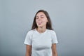 Teen in white t-shirt shows her tongue in jest. Gils looks childish and windy.