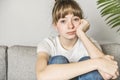 Teen woman anxious worried woman sitting on couch at home.