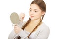 Teen woman applying lipstick looking at mirror. Royalty Free Stock Photo
