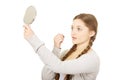 Teen woman applying lipstick looking at mirror. Royalty Free Stock Photo