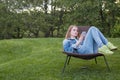 Teen woman using smartphone outside garden Royalty Free Stock Photo