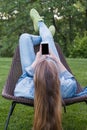 Teen woman using smartphone outside garden Royalty Free Stock Photo
