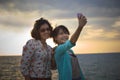 Teen and young woman take a photo by mobile phone at sea side Royalty Free Stock Photo