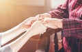 Teenage asia young girl carer holding grandma hands, concept of helping care for the elderly life with dark background, close up, Royalty Free Stock Photo