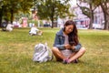 Teenage girl laying in park using mobile phone. Royalty Free Stock Photo