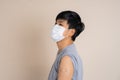 Teenage Asian wearing a mask and happily after receive covid-19 anti virus vaccine, Isolated background with copy space