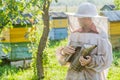 Teenage beekeeper and beehive on bee yard