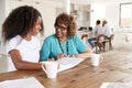 Teenage African American  girl and her grandmother looking through a photo album smiling at each other, close up Royalty Free Stock Photo
