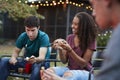 Teenage black girl making sÃ¯Â¿Â½more with friends at a fire pit Royalty Free Stock Photo