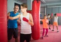 Teenage boxer with coach practicing