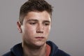 Teenage boy with acne looking down, head and shoulders portrait Royalty Free Stock Photo