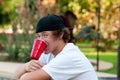 Teenage boy with acne and red cup in mouth looking at camera. Royalty Free Stock Photo