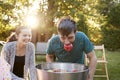 Teenage boy, apple in mouth, apple bobbing at garden party Royalty Free Stock Photo