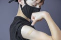 Teenage boy with bandage plaster on his arm makes fist and flexes her bicep after vaccination. Injection covid vaccine Royalty Free Stock Photo