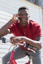 Teenage Boy On Bike Talking on Mobile Phone Outdoors Royalty Free Stock Photo