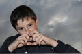 Teenage boy in black hoodie against dark cloudy sky Royalty Free Stock Photo