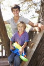 Teenage Boy And Brother Playing In Tree House Together Royalty Free Stock Photo