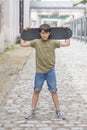 A teenage boy carrying skateboard and smiling Royalty Free Stock Photo