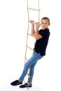 Teenage boy climbiing on rope ladder