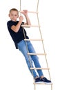 Teenage boy climbiing on rope ladder