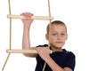Teenage boy climbiing on rope ladder. Photo session in the studio