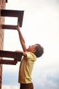 Teenage boy climbs a brick wall to the roof Royalty Free Stock Photo