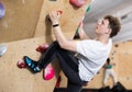 Teenage boy climbs steep artificial wall in sports complex and trains endurance Royalty Free Stock Photo