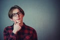 Teenage boy confident thinking, keeps one hand under chinlooking away isolated on grey wall background with copy space. Adolescent Royalty Free Stock Photo