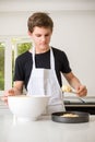 A Teenage Boy Cooking In A Kitchen